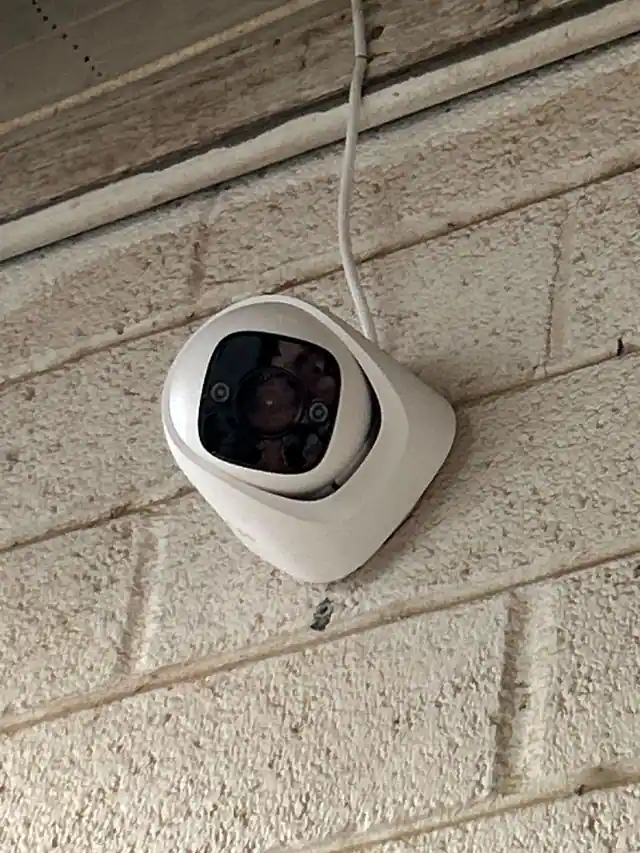 Dome camera installed on an exterior brick wall