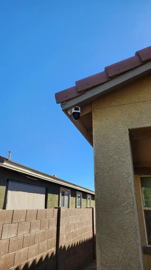Dual-lens exterior camera mounted beneath a roof eave