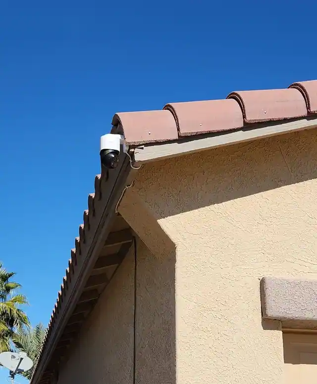 Pan-and-tilt camera mounted at a tile-roof corner